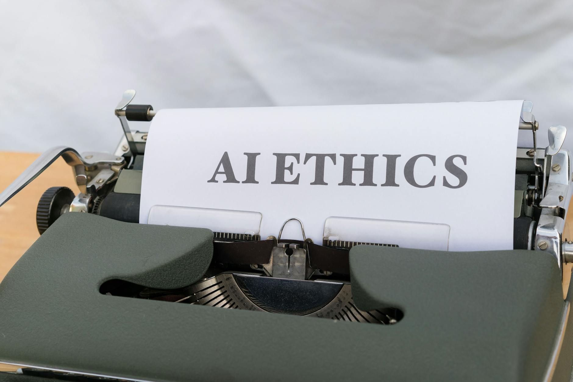 Zbliżenie na maszynę do pisania z napisem AI ETHICS na kartce