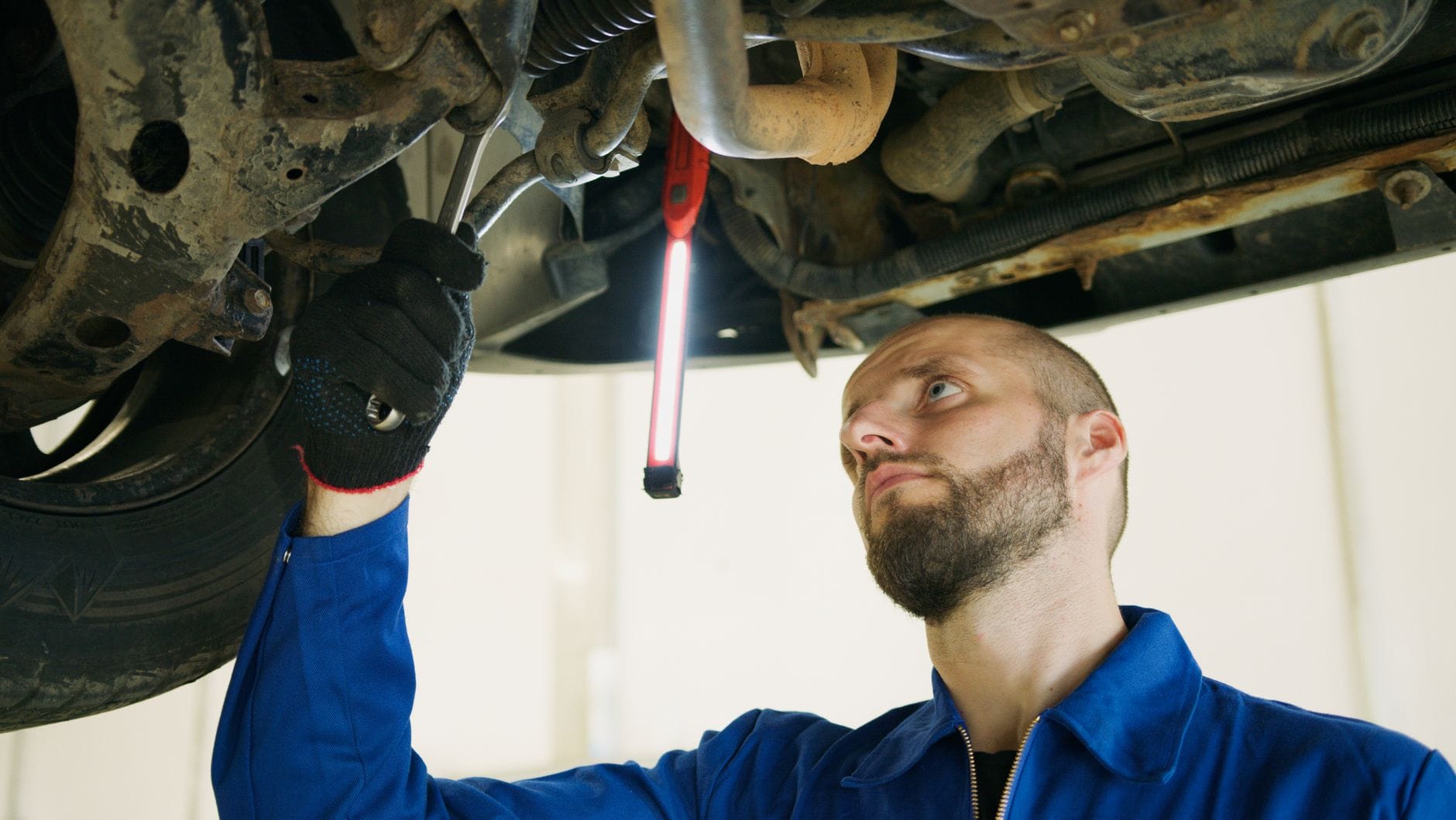 Mechanik podniesionego auta sprawdza układ kierowniczy w garażu